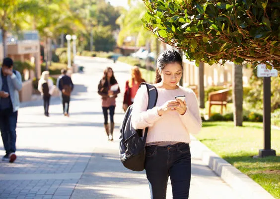 A woman walking outdoors on her mobile phone
