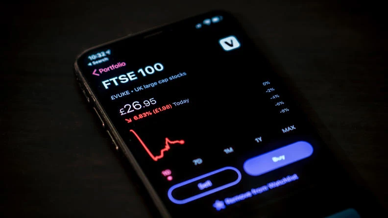 A FTSE 100 business stocks shown on a mobile phone