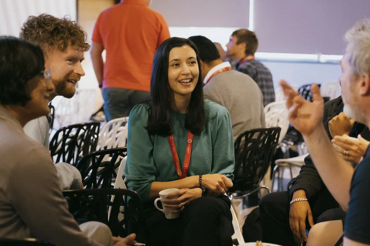 A group of people talking and smiling together.