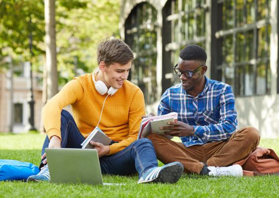 Two students sat outdoors working